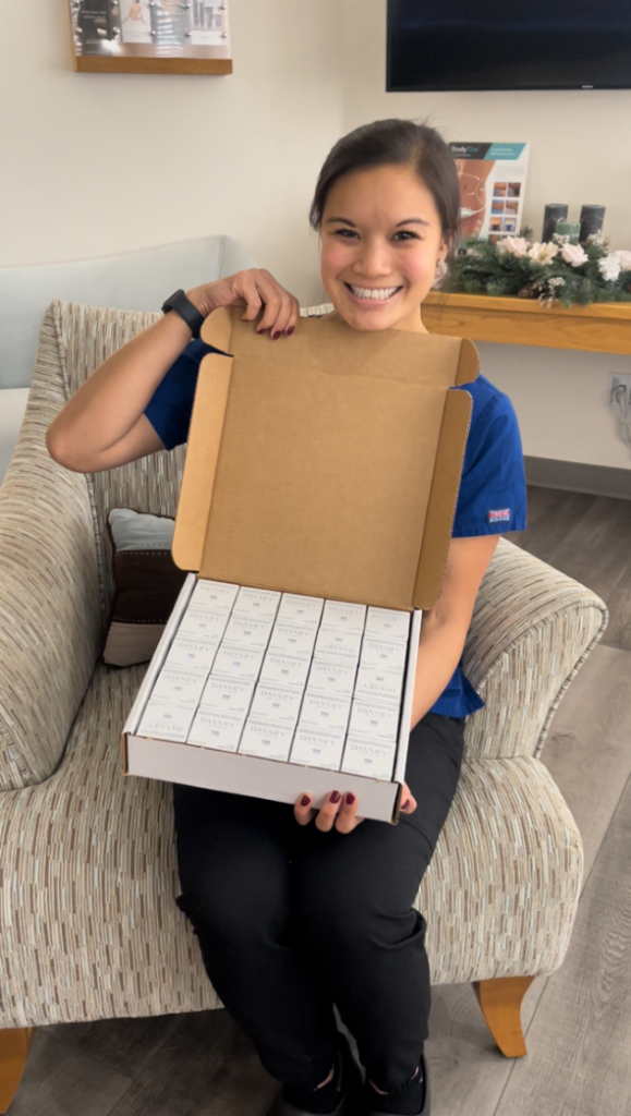 Staff worker holding open box of Daxxify products